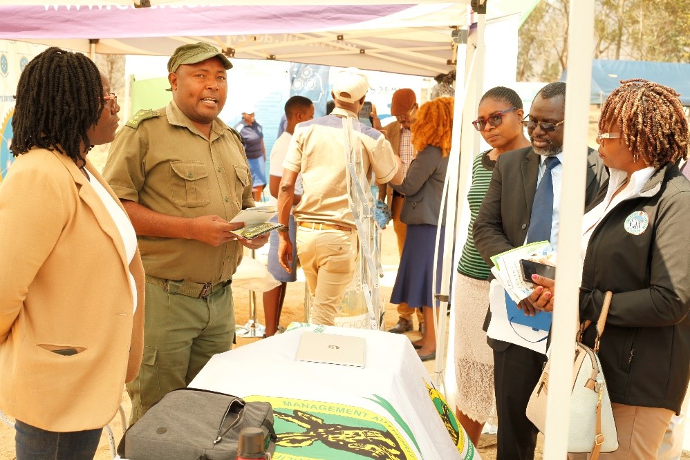 Exhibitors showcasing their products to dignitaries at the symposium.